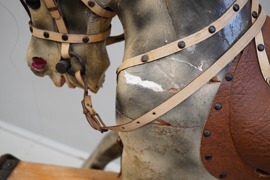 An early 20th century dapple grey rocking horse, on later trestle base, length 132cm. Condition - fair.